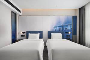 Una cama o camas en una habitación de Hampton by Hilton Nanjing North Railway Station