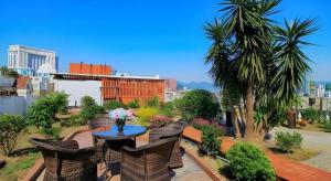 a patio with chairs and a table with flowers on it at GreenTree Inn Fuzhou Gulou District West Xierhuan Road Zuohai Park in Fuzhou