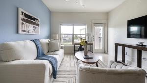 a living room with a white couch and a tv at Landing Apartments Austin - Lockhart in Lockhart