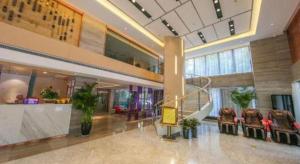 a lobby with chairs and a staircase in a building at Lavande Hotel·Wuhan Qingshan Zhongyuan Plaza in Wuhan