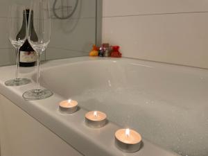 two candles and two wine glasses and a bath tub at Ferienhaus Hirschle | Sauna | Hunde | Zaun in Schömberg +23 photos