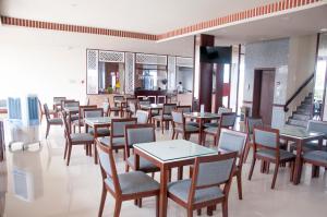 Ozon Hotel في Năm Căn: غرفة طعام مليئة بالطاولات والكراسي