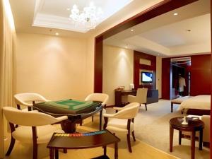 a room with a table and chairs and a bedroom at Huangshan Shuguang Yusong Hotel in Huangshan