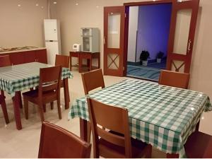 a dining room with a table and chairs and a kitchen at GreenTree Alliance Changzhou University City Hotel in Changzhou