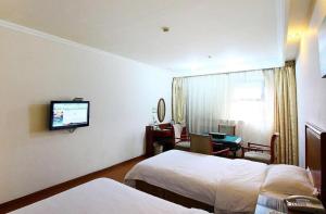 a hotel room with two beds and a television at GreenTree Alliance Changzhou University City Hotel in Changzhou