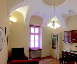 a living room with a window and a chandelier at Palazzo di Città in Saluzzo