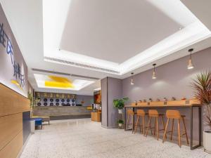 a lobby with a bar with stools at 7 Days Inn Wuhan Dingziqiao Zhongnan Road Metro Station in Wuhan