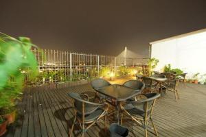 a row of tables and chairs on a deck at night at GreenTree Inn Fujian Fuzhou Software Park River View Business Hotel in Fuzhou