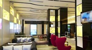 a living room with red chairs and a television at LAVANDE Hotel Dalian Huanan Square North Railway Station in Dalian