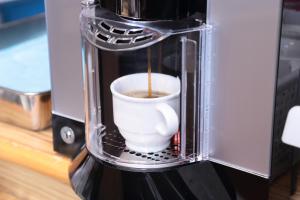 a cup of coffee is being made in a coffee maker at Access Inn Kariya in Kariya