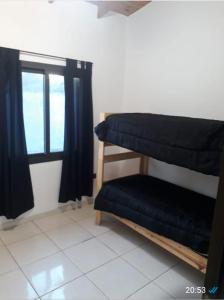 a room with two bunk beds and a window at Casa El Aromito Anisacate in Villa Anizacate