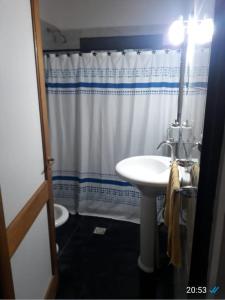 a bathroom with a sink and a shower curtain at Casa El Aromito Anisacate in Villa Anizacate