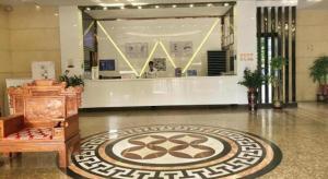 a lobby with a large rug on the floor at Wenxing Hotel Dongguan Qifeng Branch in Dongguan