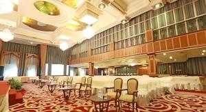 a banquet hall with tables and chairs in a building at Gajahmada Graha Hotel in Malang