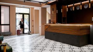 ビシュケクにあるOrto Asia Hotel Bishkekの店のカウンターに立つ女