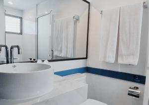 a white bathroom with a sink and a mirror at Days Inn by Wyndham Patong Beach in Patong Beach