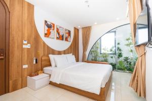 a bedroom with a bed and a large window at Azure Bay Hotel in Ha Long