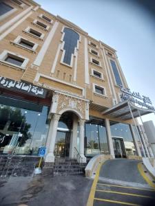 a large building with a staircase in front of it at ساتورن هاوس للشقق الفندقية in Tabuk