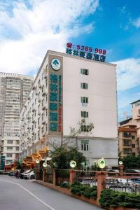 Un bâtiment blanc avec une horloge en haut dans l'établissement GreenTree Inn Nanning Langdong Hotel, à Nanning
