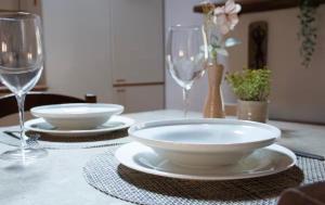 a table with two plates and two wine glasses at Loft Santa Anastasia - Piazza delle Erbe in Verona
