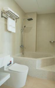 a bathroom with a toilet and a bath tub at Azure Bay Hotel in Ha Long +19 photos