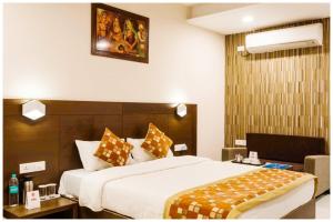 a hotel room with a large bed at Hotel Shriniwash Residency Near Shri Mahakaleshwar Jyotirlinga Temple in Ujjain