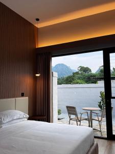 a bedroom with a bed and a balcony with a table at Tambuna Retreat ,TAMBUN ,IPOH in Tambun