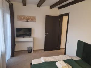 a bedroom with two beds and a flat screen tv at Refugiul Domnitei in Bran