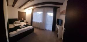 a bedroom with a bed and a window and a television at Refugiul Domnitei in Bran