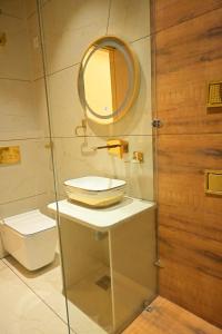 a bathroom with a mirror and a sink and a toilet at Shree shyam hotel & restaurant in Mahendragarh