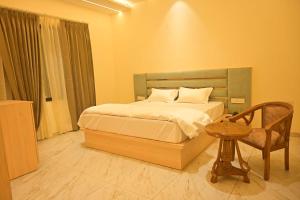 a bedroom with a bed and a chair and a table at Shree shyam hotel & restaurant in Mahendragarh