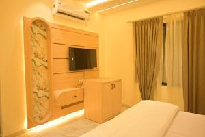 a bedroom with a bed and a tv in a room at Shree shyam hotel & restaurant in Mahendragarh