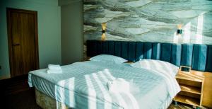 a bedroom with a bed with a painting on the wall at Orto Asia Hotel Bishkek in Bishkek
