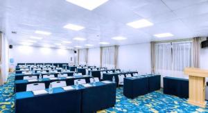 a room with rows of tables and chairs at Echarm Hotel Nanning Nationalities Square Metro Station in Nanning