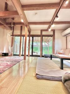 a large room with a bed and a table at 和心村ー古民家とグランピングと自然森山川海 in Minato +76 photos