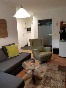 Sehma2-Personen-Apartment的客厅配有沙发、椅子和桌子