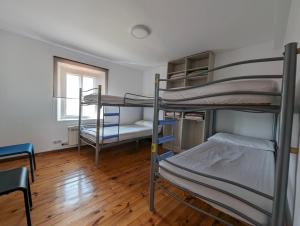 a room with three bunk beds and a window at Albergue El Alfar/Pilgrim Hostel in Hornillos del Camino