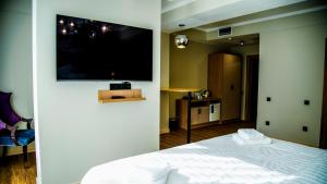 ビシュケクにあるOrto Asia Hotel Bishkekのベッドと薄型テレビのある寝室