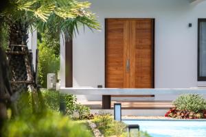 una casa con una puerta de madera y un banco en Lanna Fusion, en Hang Dong 105 fotos más