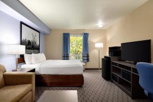 Swan RiverにあるSuper 8 by Wyndham Swan River MBのベッドと薄型テレビがあるホテルの部屋