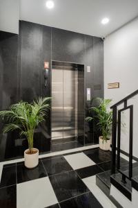 een lobby met twee potplanten in een lift bij Hotel SK Elite in Jodhpur