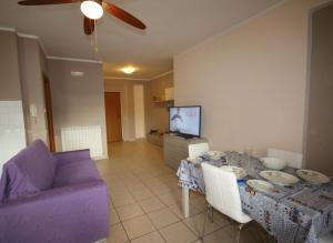 イトリにあるUniversal Apartments Itri Cのリビングルーム(テーブル、紫色のソファ付)