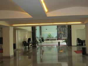 Un vestíbulo con un escritorio y sillas en un edificio. en Kenari Tower Hotel, en Makassar 221 fotos más