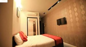 Cette chambre dispose d'un lit et d'une télévision murale. dans l'établissement Gia Hoa Hotel, à Vung Tau