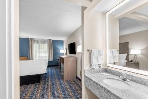 ein Hotelzimmer mit einem Bad mit einem Waschbecken und einem Bett in der Unterkunft Quality Inn Shepherdstown in Shepherdstown + 32 Fotos