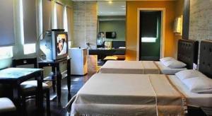 a room with two beds and a tv in it at Jardin de Rosal Hotel in Manila