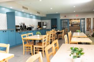 a restaurant with blue cabinets and wooden tables and chairs at Country Inn & Suites by Radisson, Prairie du Chien in Prairie du Chien