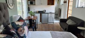 a kitchen and living room with a couch and a table at Fevertree cottage in Bloemfontein