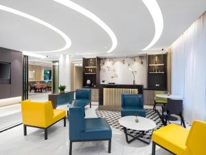 a waiting room with colorful chairs and tables at Magnotel Shanghai Maglev Station in Shanghai