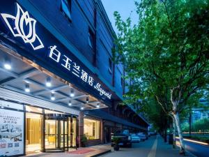 a store with a sign on the side of a building at Magnotel Shanghai Maglev Station in Shanghai